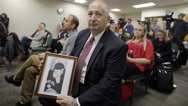 Mark Lewis holds a photograph of his 27-year-old son who died from a heroin overdose at a conference on the opioid crisis in