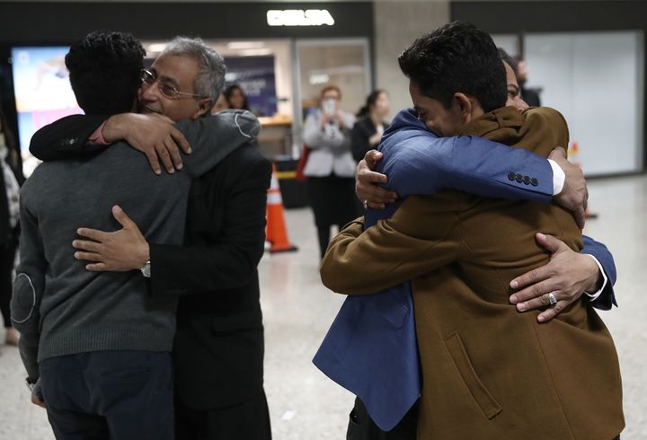 Brothers Ammar and Tareq Aqel Mohammed Aziz hug their father and uncle after arriving in Dulles International Airport.