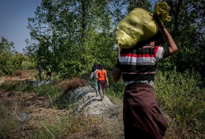 A Rohingya family fleeing from Dekibonia village in Myanmar crosses into Bangladesh on Feb. 6.