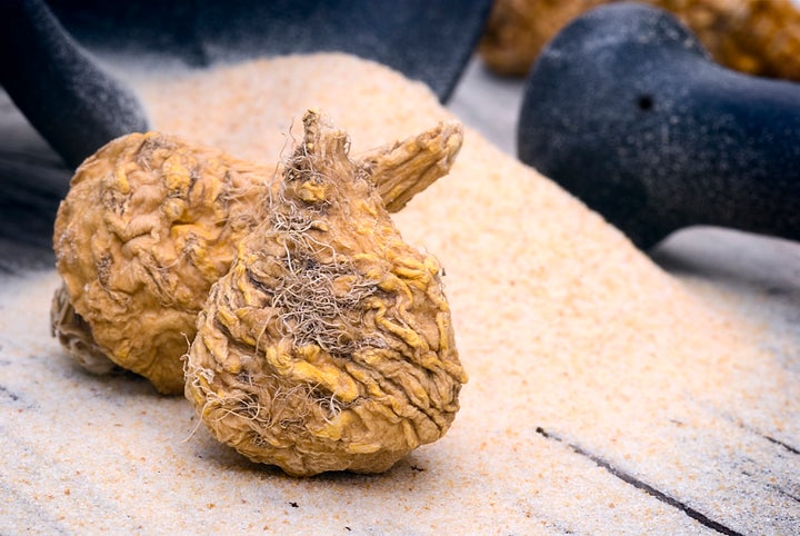 A couple of dried maca roots in front of a pile of ground maca.