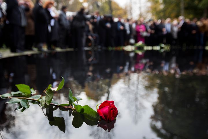People lay flowers during the inauguration of the Memorial to the Sinti and Roma of Europe Murdered under National Socialism in Berlin on Oct. 24, 2012.