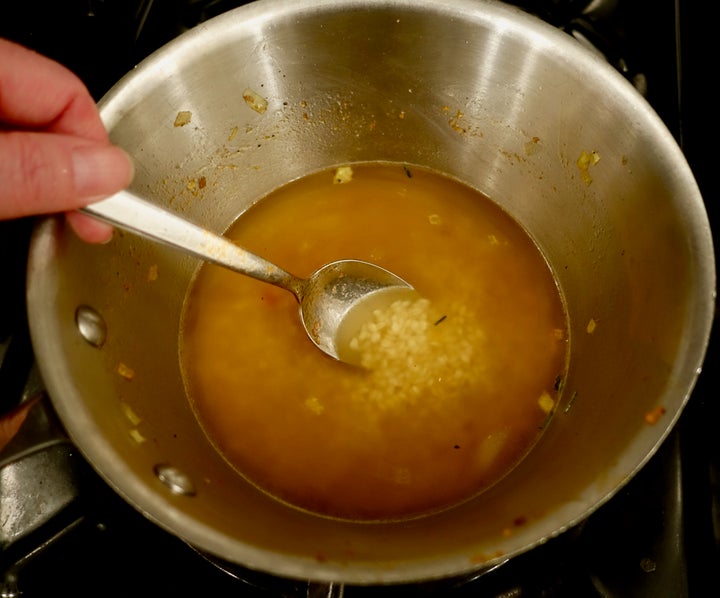 <p>Vialone nano rice and vegetable stock in the unwashed pan from the sausage mixture</p>