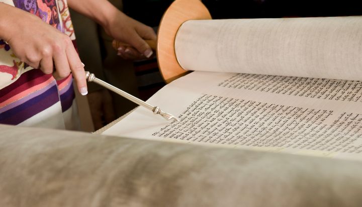 A woman reads from Torah.