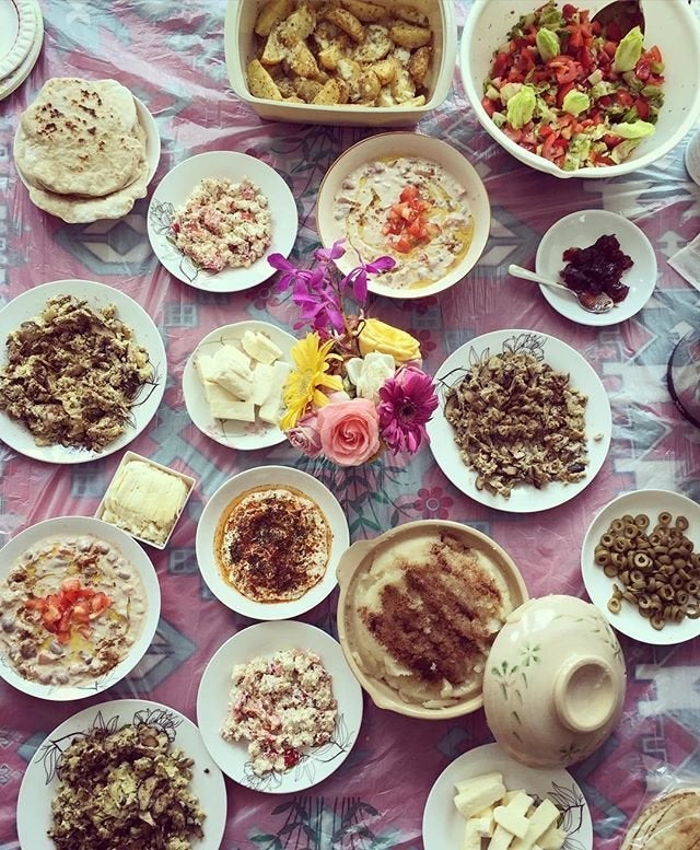 A Syrian Breakfast spread of cheese, bread, olives, fresh vegetable salad, fattet hummus, among other dishes.