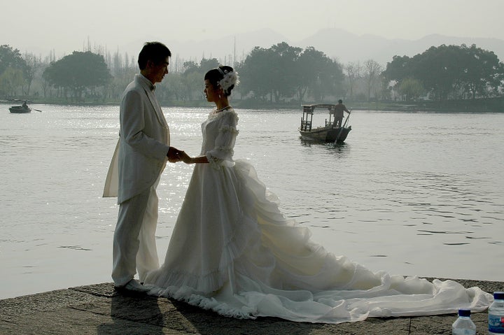 <p><em>Hangzhou is the “City of Love”: a bridal couple poses for pictures on the bank of West Lake</em></p>