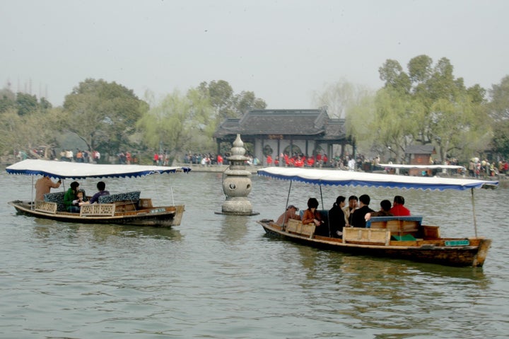 Traditional boats on West Lake pull up to the famous pagodas, just off Yingzhou Islet