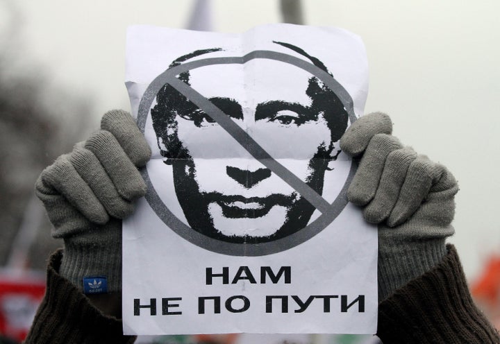 A protester holds a poster with an image of then-Russian Prime Minister Vladimir Putin reading, 'We are going different ways,' during a mass rally against election fraud in central Moscow, Russia, on Dec. 10, 2011.