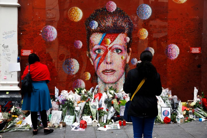 People look at a mural of David Bowie in Brixton, London. 