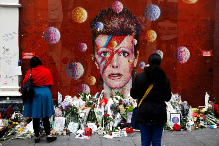 People look at a mural of David Bowie in Brixton, London. 