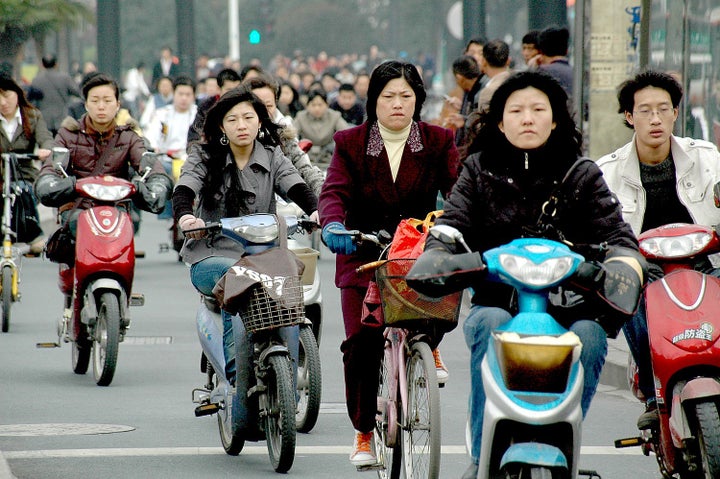  Braving the traffic: bikes and mopeds cram their lane on the streets of Hangzhou