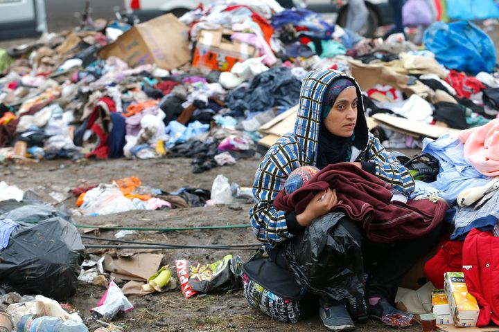 A mother breastfeeds her baby in front of piles of rubbish at a migrant collection point in Roszke, Hungary on Sept. 11, 2015.