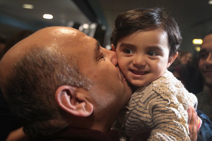 Khaled Haj Khalaf kisses his grandaughter Shams after she arrived with her mother and father at O'Hare Airport on a flight from Istanbul on Tuesday. Shams' parents had spent five years in a Syrian refugee camp in Turkey. Their trip to the United States was suspended after President Donald Trump signed an executive order stopping Syrian refugees from entering the U.S..