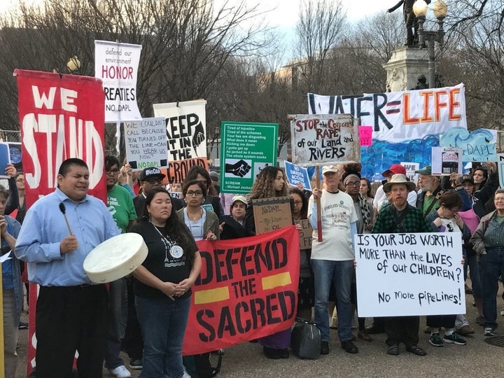 Demonstrators listen to a prayer song Wednesday outside the White House.