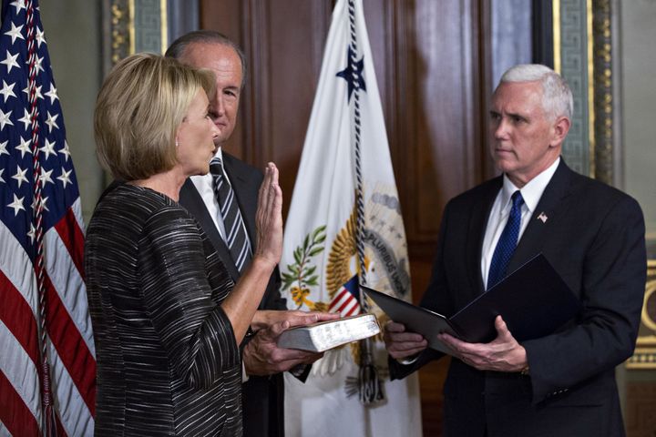 U.S. Vice President Mike Pence, right, swears in Betsy DeVos as U.S. secretary of education.