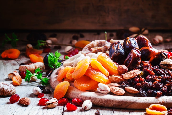 A plate of dried apricots, cranberries and dates.