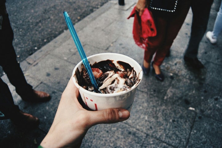 Frozen yogurt, topped with strawberries and hot fudge.