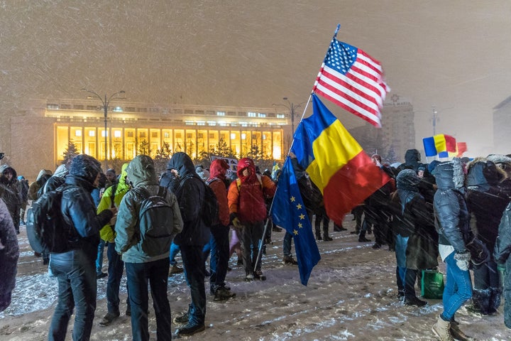 Protesters gather in front of the government building in Victory Square, Bucharest, Romania. 