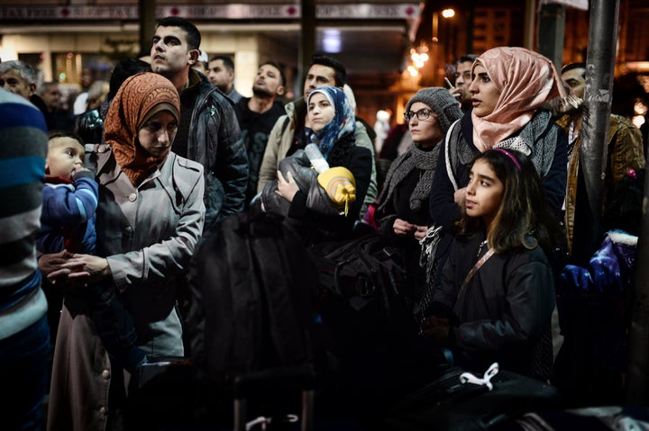 Refugees wait for a bus heading to the airport in Athens to take a special charter flight bound for France. The group consist