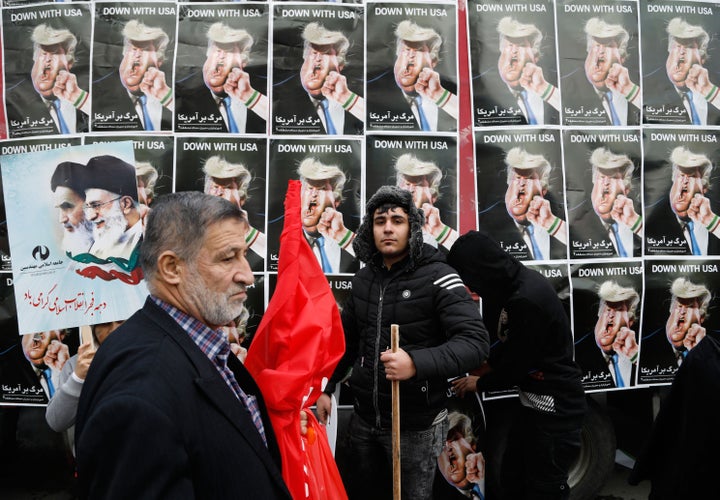 An Iranian man stands in front of placards showing a caricature of President Donald Trump during a rally marking the anniversary of the 1979 Islamic revolution on Feb. 10, 2017.