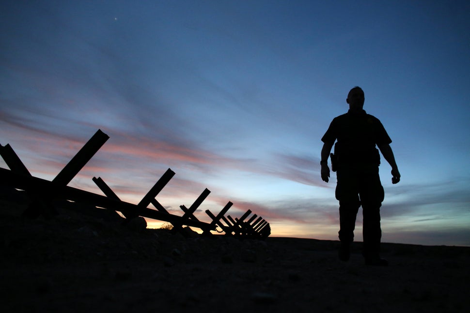 U.S. border patrol agent Alessio Faccin walks along the border fence separating Mexico from the U.S.&nbsp;near Calexico, Cali