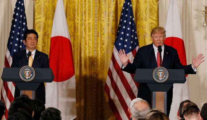Shinzo Abe looks on as Donald Trump speaks during the press conference