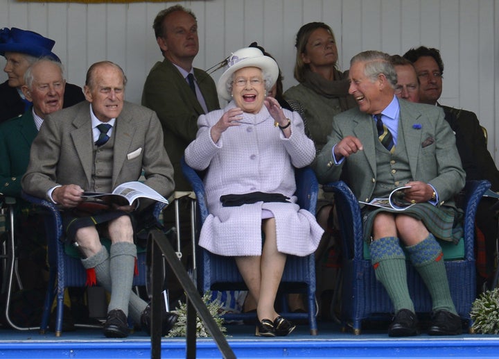 Philip, Elizabeth and their son Prince Charles cheer during the Braemar Gathering highland games in Braemar, Scotland, on Sep