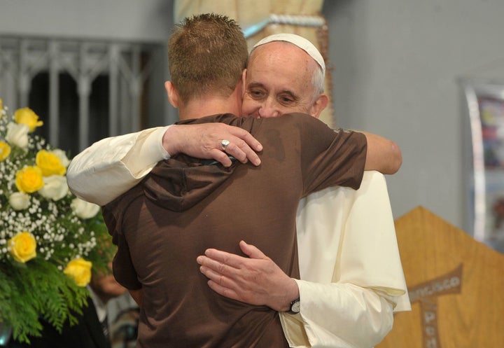 Pope Francis hugs a man in his visit to a rehab hospital. 