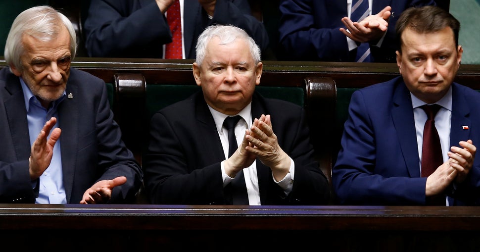 Leader of the ruling party PiS Jaroslaw Kaczyński and other officials applaud after opposition party members leave the podium