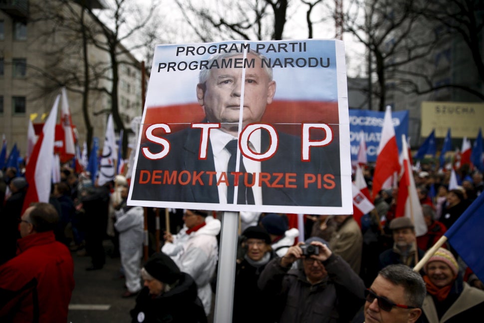 A man holds a banner with Jaroslaw Kaczyński, leader of Poland's ruling PiS party, that reads "Stop Demoktaturze (a combinati