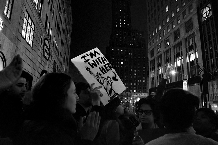 Using a play on words on Hillary Clinton’s campaign slogan, a protester outside Trump Tower decries the outcome of the 2016 P