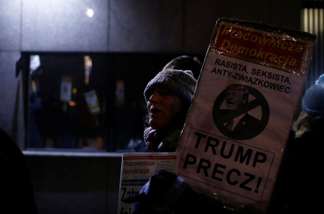 A woman holds a placard saying "Trump Away!" as people gather to protest against U.S. President Donald Trump in front of the U.S. embassy in Warsaw, Poland on Jan. 20, 2017.