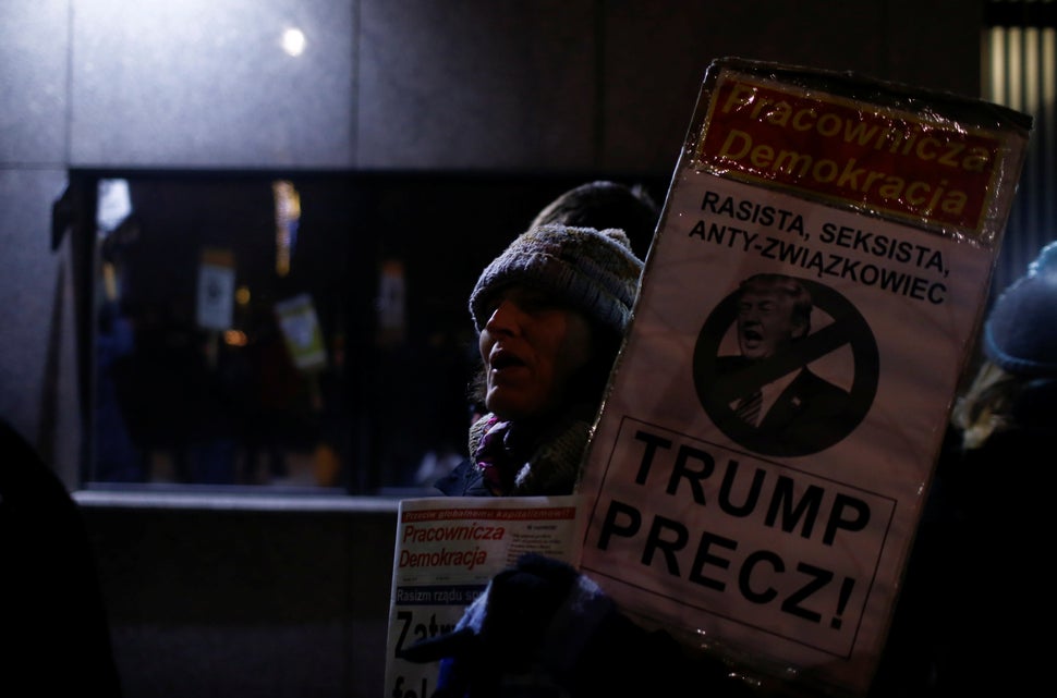 A woman holds a placard saying "Trump Away!" as people gather to protest against U.S. President Donald Trump in front of