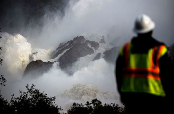 A water utility worker looks on as water is released down a spillway as an emergency measure at the Oroville Dam on Monday.