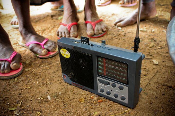 Farmers gather around a radio in northern Ghana