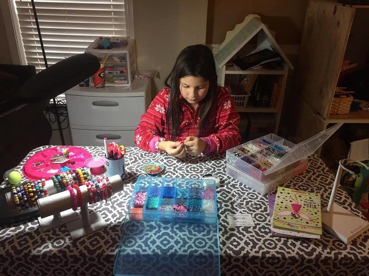 Bella set up shop in her playroom to make bracelets, which she sells to raise money for the dolls.