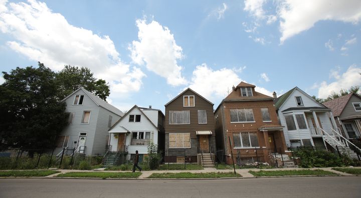<p>A man walks past five foreclosed homes in Chicago, July 21, 2010.</p>