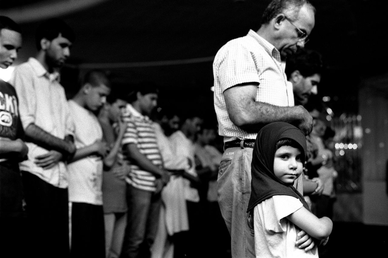 Robert Gerhardt, "Young Girl at Prayers with Her Father, Muslim American Society," Brooklyn, New York, 2010.