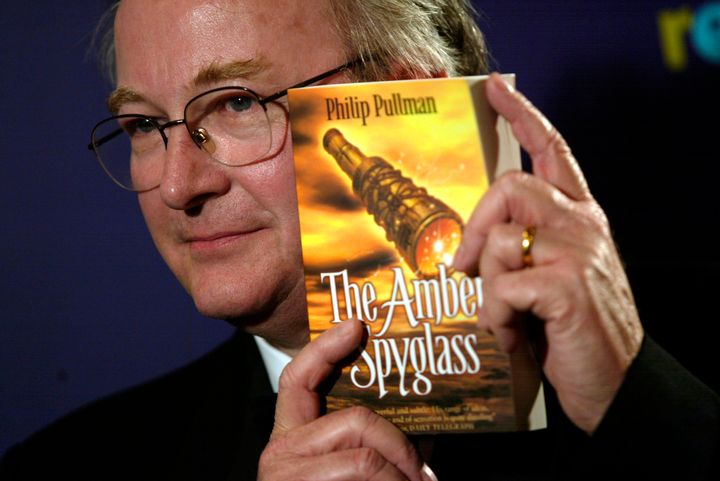 Pullman holding up the final installment of the "His Dark Materials" trilogy.