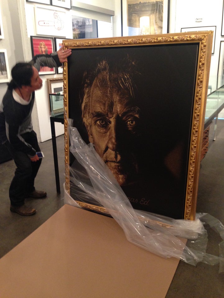 Artist Dennis Mukai unwrapping his work