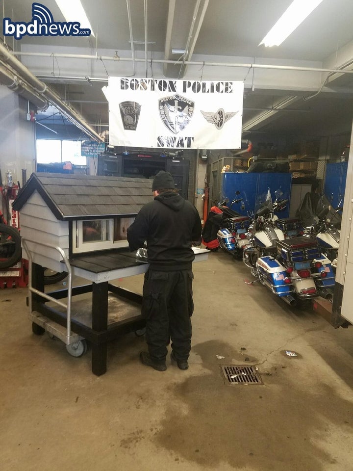 An unidentified officer works on SWAT Cat's housing.