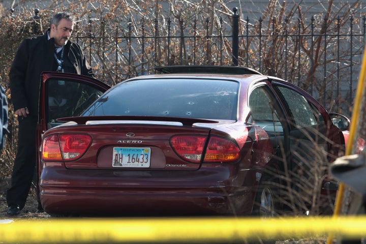 Police look over a car after a gunman opened fire Tuesday, killing a 2-year-old child and a man in his 20s and wounding a pregnant woman in the Lawndale neighborhood in Chicago.