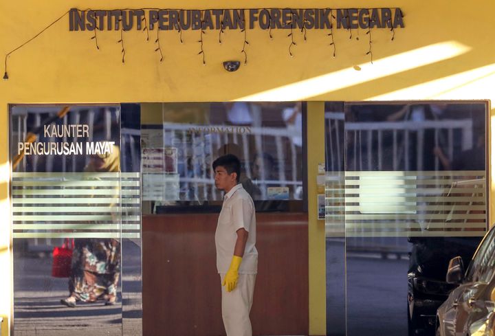 A medical staff member stands at the entrance of the forensic department at a hospital in Kuala Lumpur, Malaysia,.