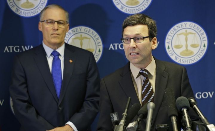 Washington Attorney General Bob Ferguson, right, talks to reporters with Gov. Jay Inslee in Seattle on Jan. 30.