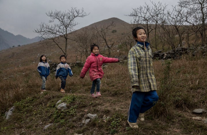 'Left behind' children from right to left, Luo Gan,10, Luo Hongniu, 8, Luo Lie, 5, and Luo Hongni, 11, walk together while doing chores in the fields on December 18, 2016 in Anshun, China.