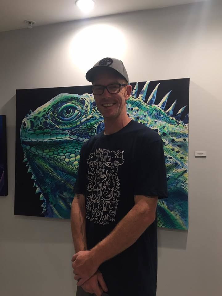 Artist/Gallerist Derek Donnelly with one of his “Lizard King” paintings.