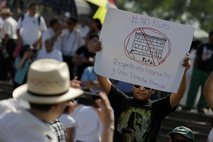 A demonstrator holds a placard reading: "No wall. Respect to immigrants and human rights" during a protest against President