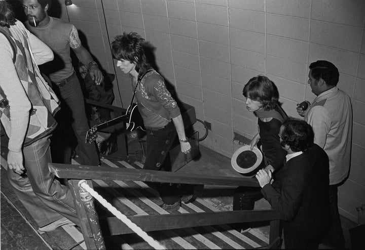 <p>The Rolling Stones take the stage in 1969; Schneider is seen holding railing next to Mick Jagger.</p>