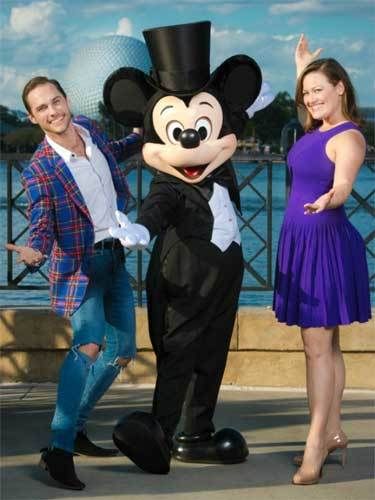Josh Strickland & Ashley Brown pose with Disney’s main mouse at the edge of Epcot’s World Showcase Lagoon.