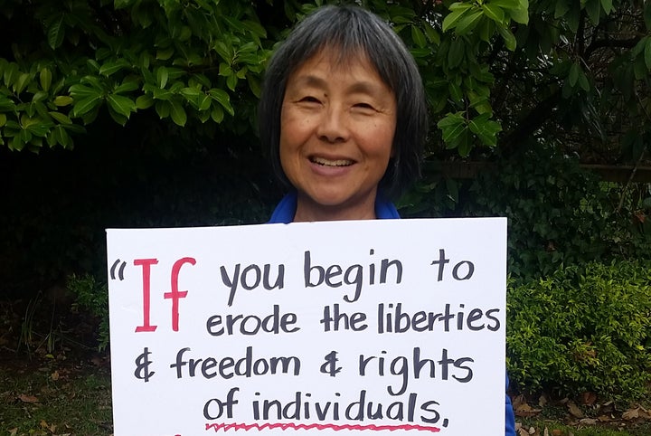 Barbara Yasui holds a sign featuring a quote from her uncle, civil liberties activist Minoru Yasui, on Jan. 21, 2017. The ent
