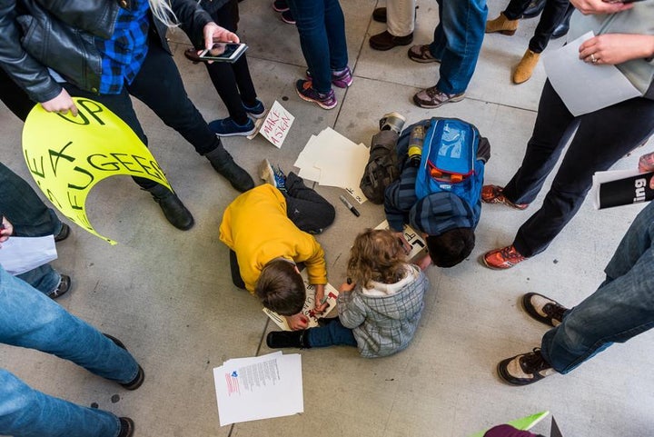 <p>Three children make signs for the immigration protest at Hartsfield-Jackson International Airport, Sunday, January 29, 2017.</p>